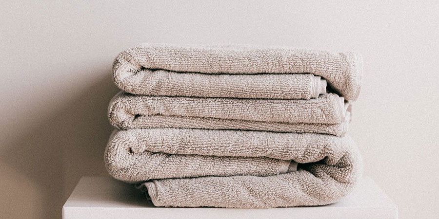 stack of fresh gray towel on a white surface